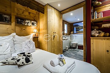 A bedroom with a cow pillow on the bed