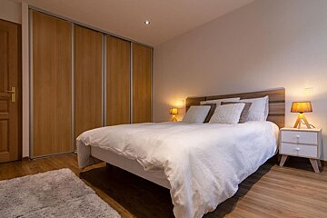 A bedroom with a bed and two lamps