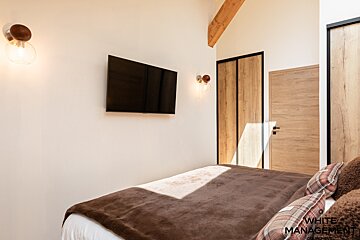 A bedroom with a large bed and a flat screen tv