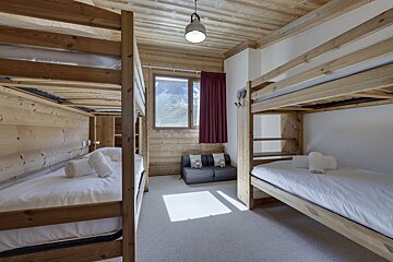 A room with bunk beds and a couch in it