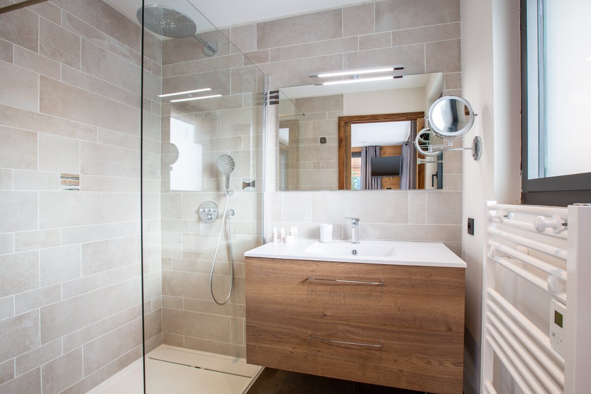 A bathroom with a walk in shower and a sink