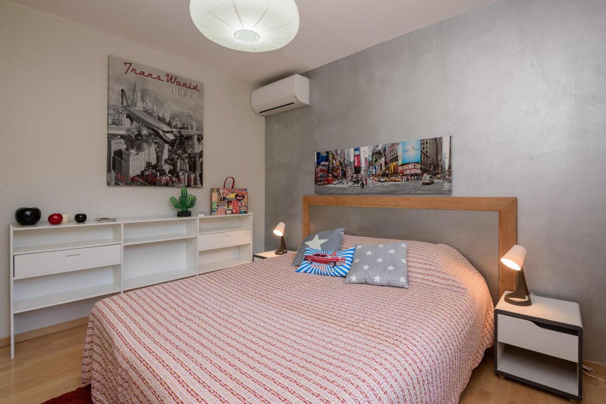 A bedroom with a painting on the wall that says 