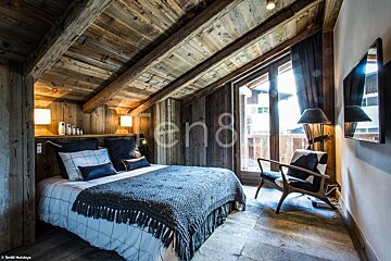 A bedroom with a bed and a chair and the number 8 on the wall