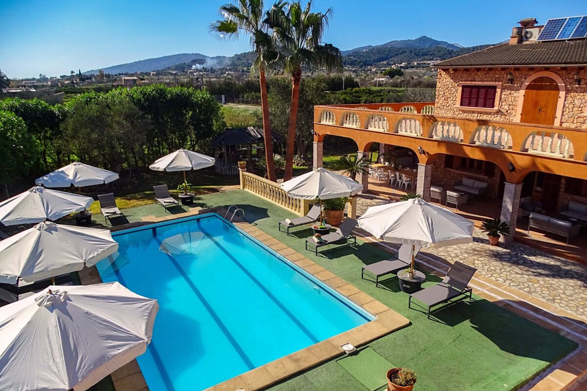 A large swimming pool surrounded by chairs and umbrellas