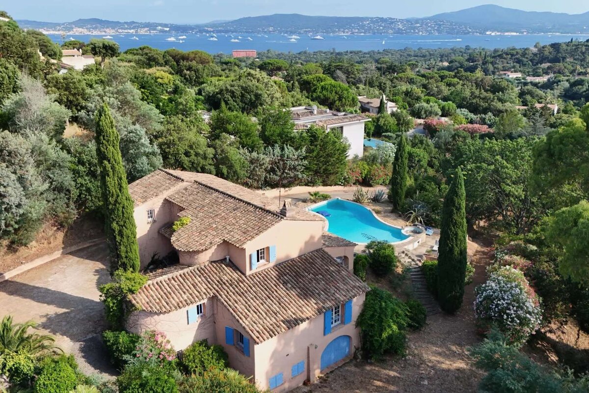 An aerial view of a house with a large pool