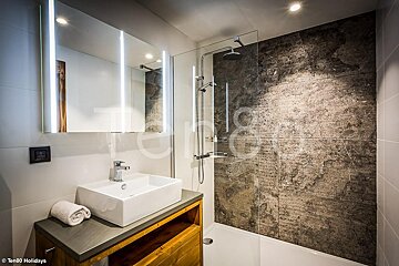 A bathroom with a sink and a shower with the words ten80 holidays on the wall