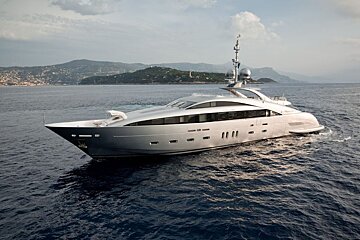 A large silver yacht is floating in the ocean