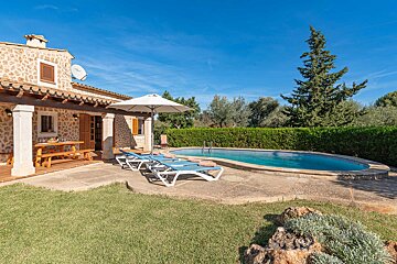 A house with a large swimming pool in front of it