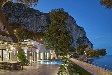 A large house with a swimming pool in front of it