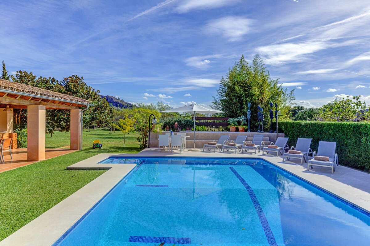 A large swimming pool surrounded by chairs and umbrellas