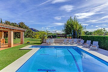 A large swimming pool surrounded by chairs and umbrellas
