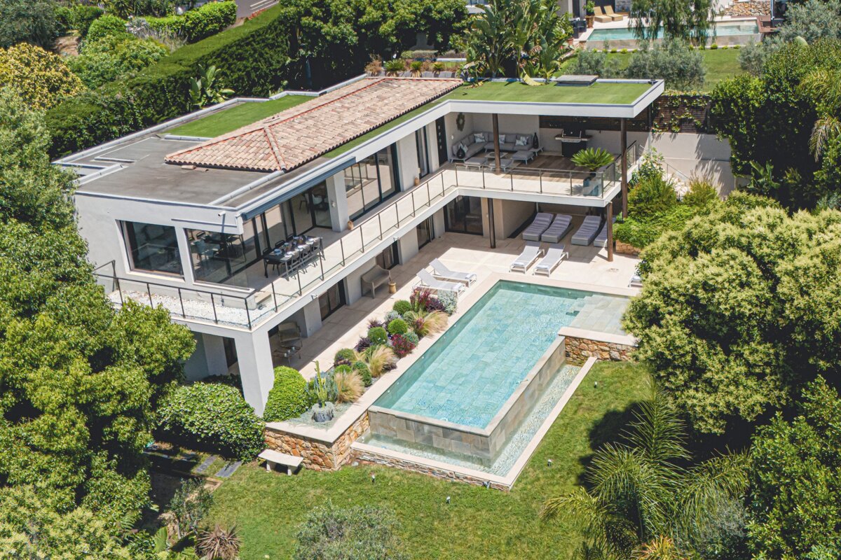 An aerial view of a large house with a swimming pool