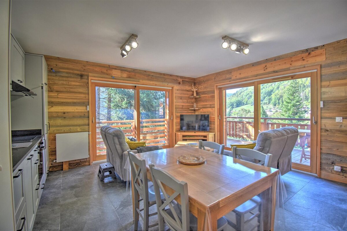 A living room with a table and chairs and a flat screen tv