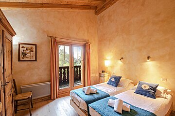 A bedroom with two beds and a picture on the wall