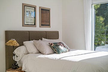 A bedroom with a bed and two framed posters one of which says grand prix