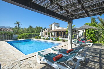 A swimming pool with a house in the background