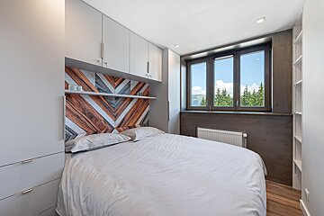 A small bedroom with a bed and a window