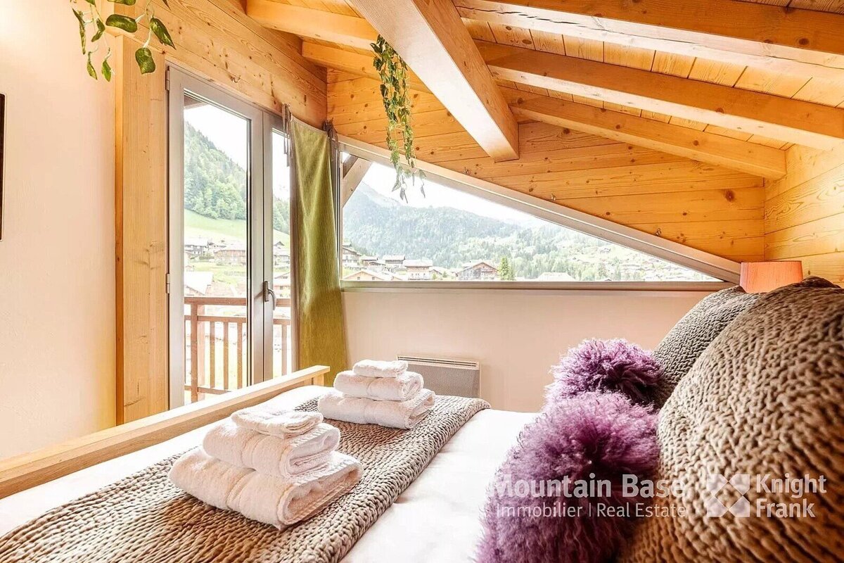 A bedroom with a bed and a window that says mountain base knight frank