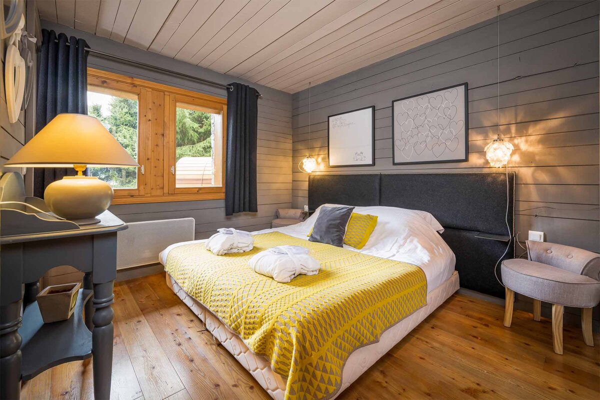 A bedroom with a yellow blanket on the bed