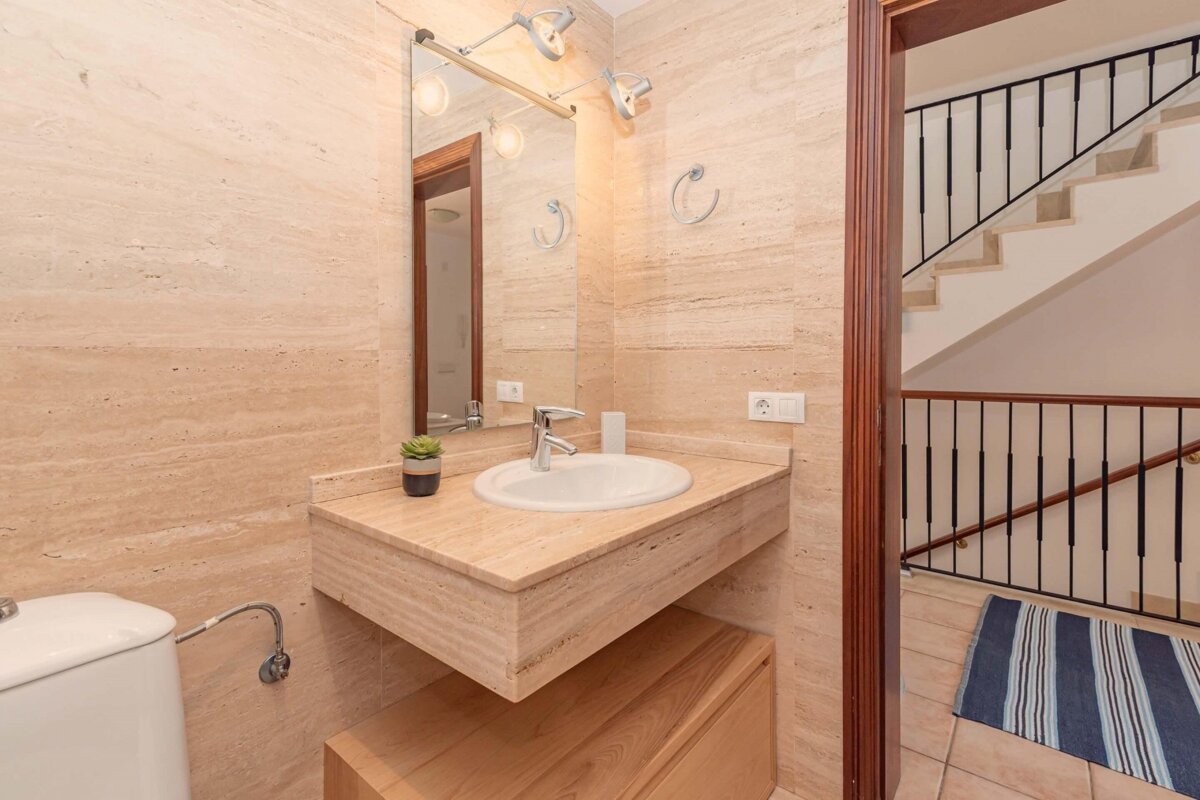 A bathroom with a sink a toilet and a staircase