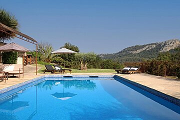 A large swimming pool with chairs and umbrellas around it