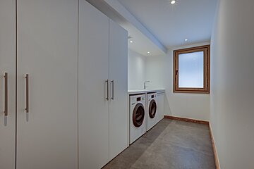 A laundry room with two washing machines and a window
