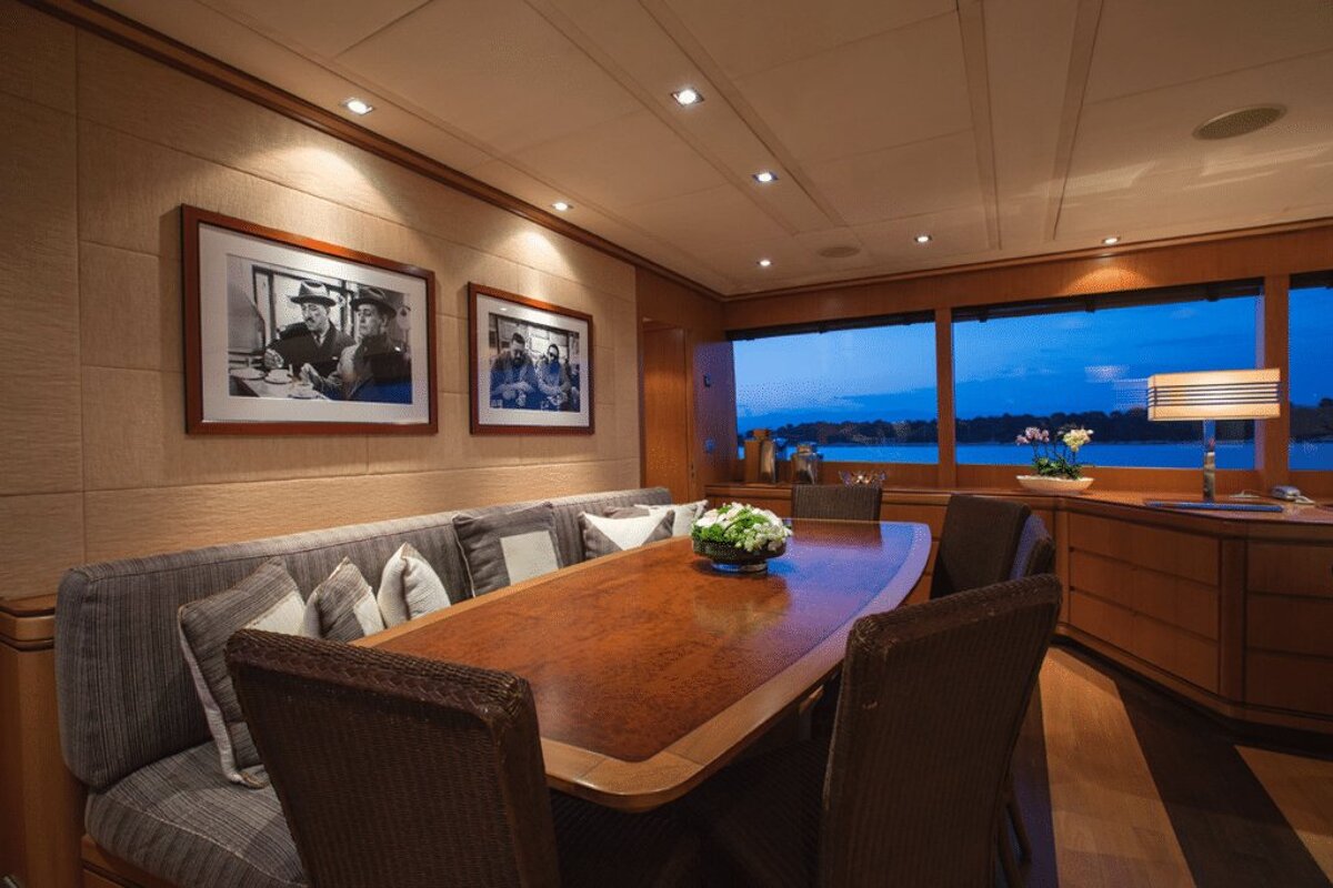 A dining room with a table and chairs and pictures on the wall