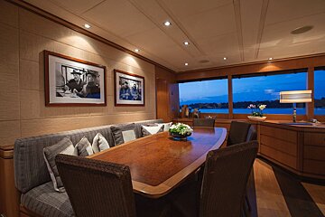 A dining room with a table and chairs and pictures on the wall