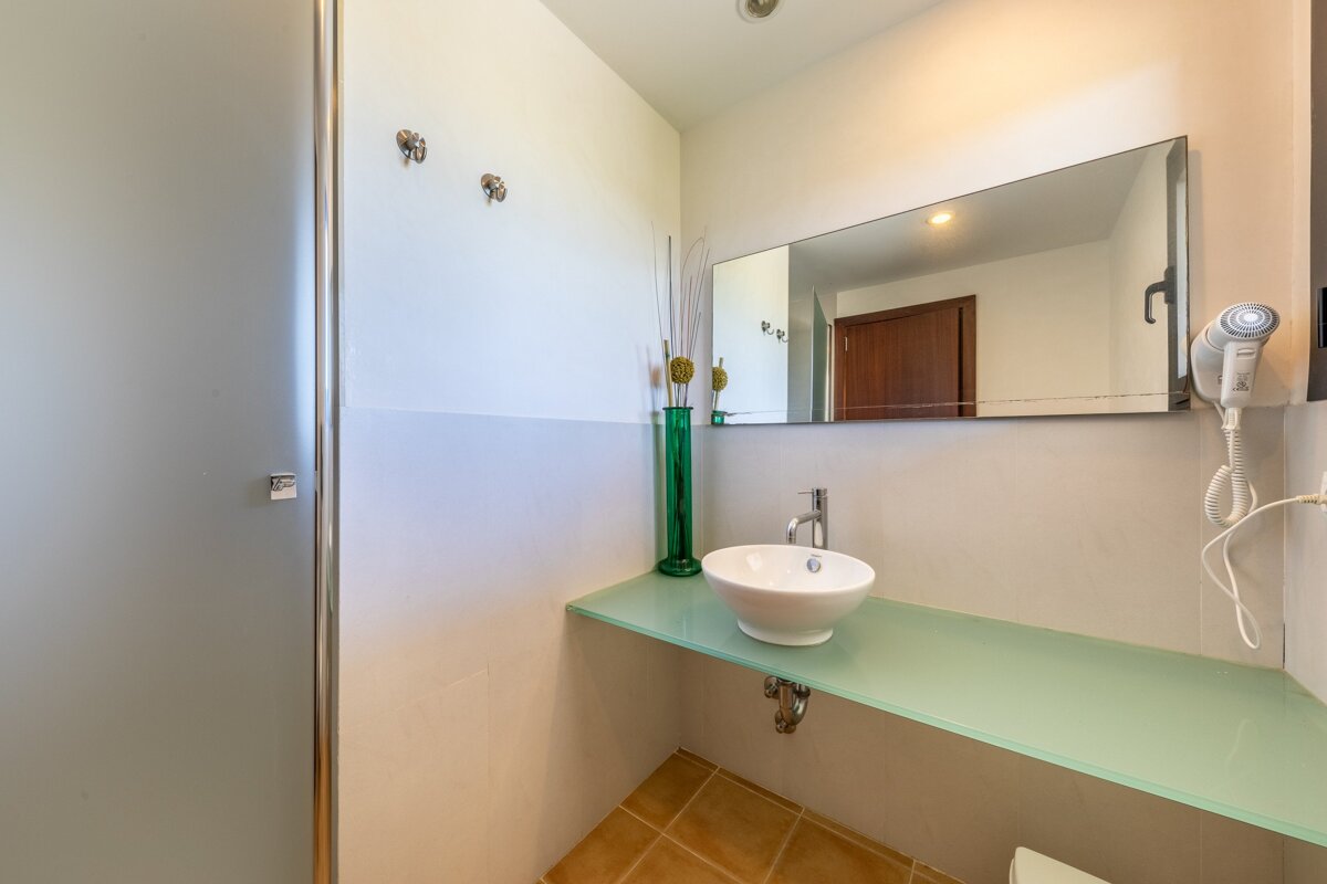 A bathroom with a sink a mirror and a hair dryer