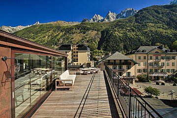 A balcony with a view of mountains and buildings