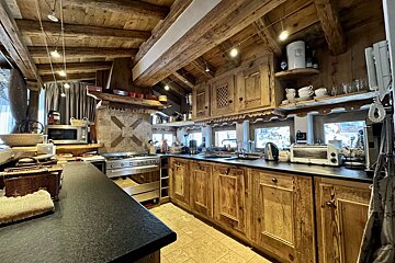 A kitchen with wooden cabinets and a black counter top