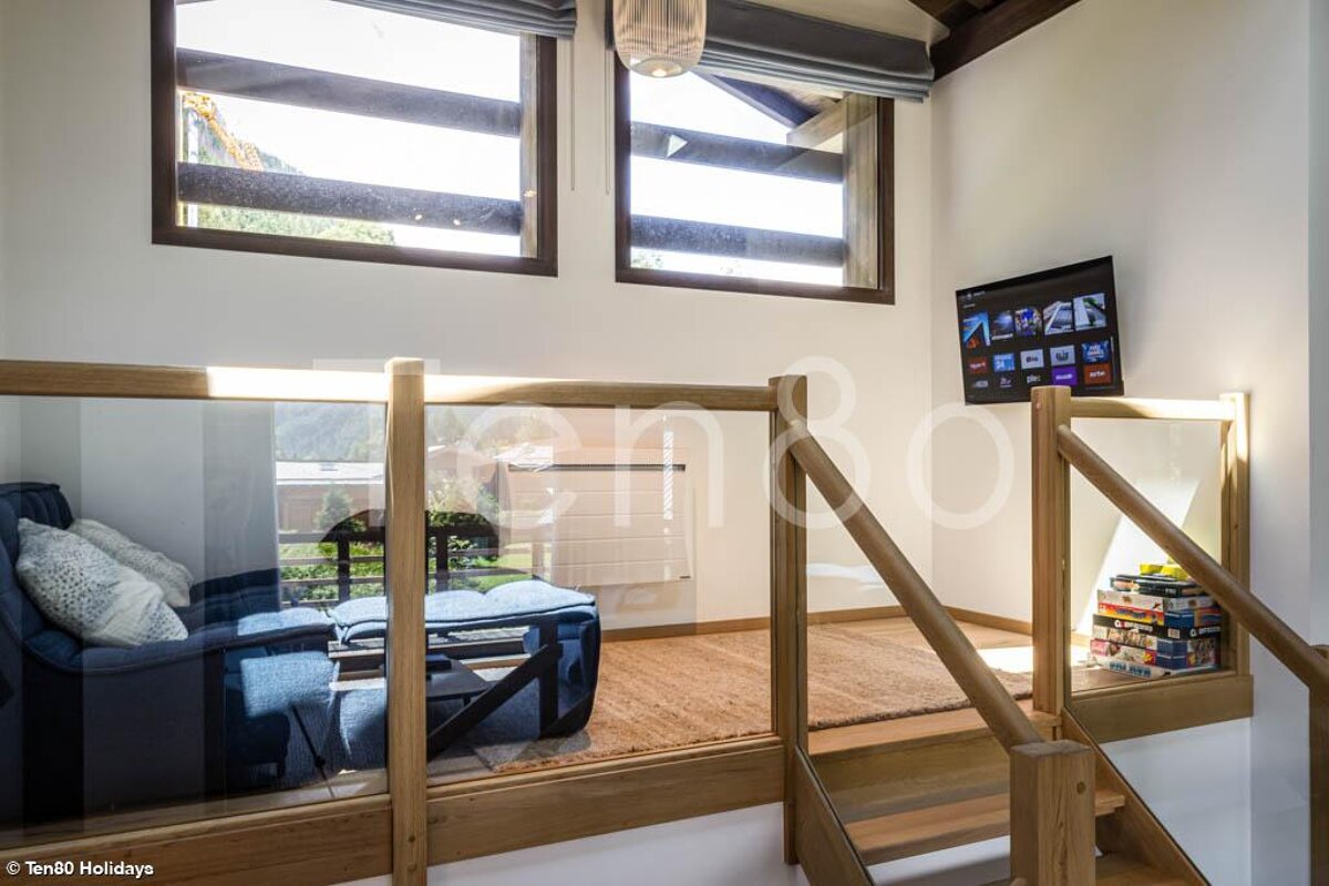 A living room with a staircase leading up to the second floor