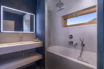 A bathroom with a sink and a bathtub with a window
