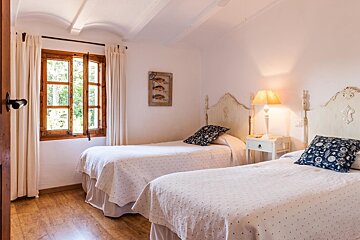 A bedroom with two beds and a picture of fish on the wall