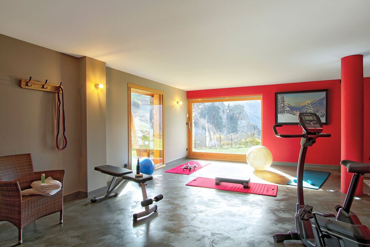 A gym with a red wall and a large window