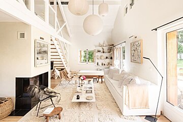 A living room with a white couch and a fireplace