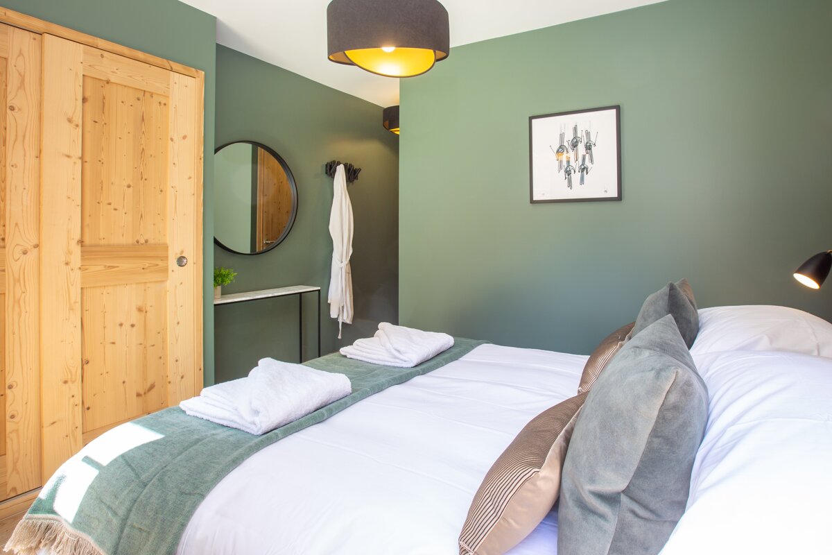 A bedroom with a bed and a picture on the wall