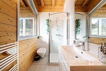 A bathroom with a toilet a sink and a shower says mountain base immobilier real estate