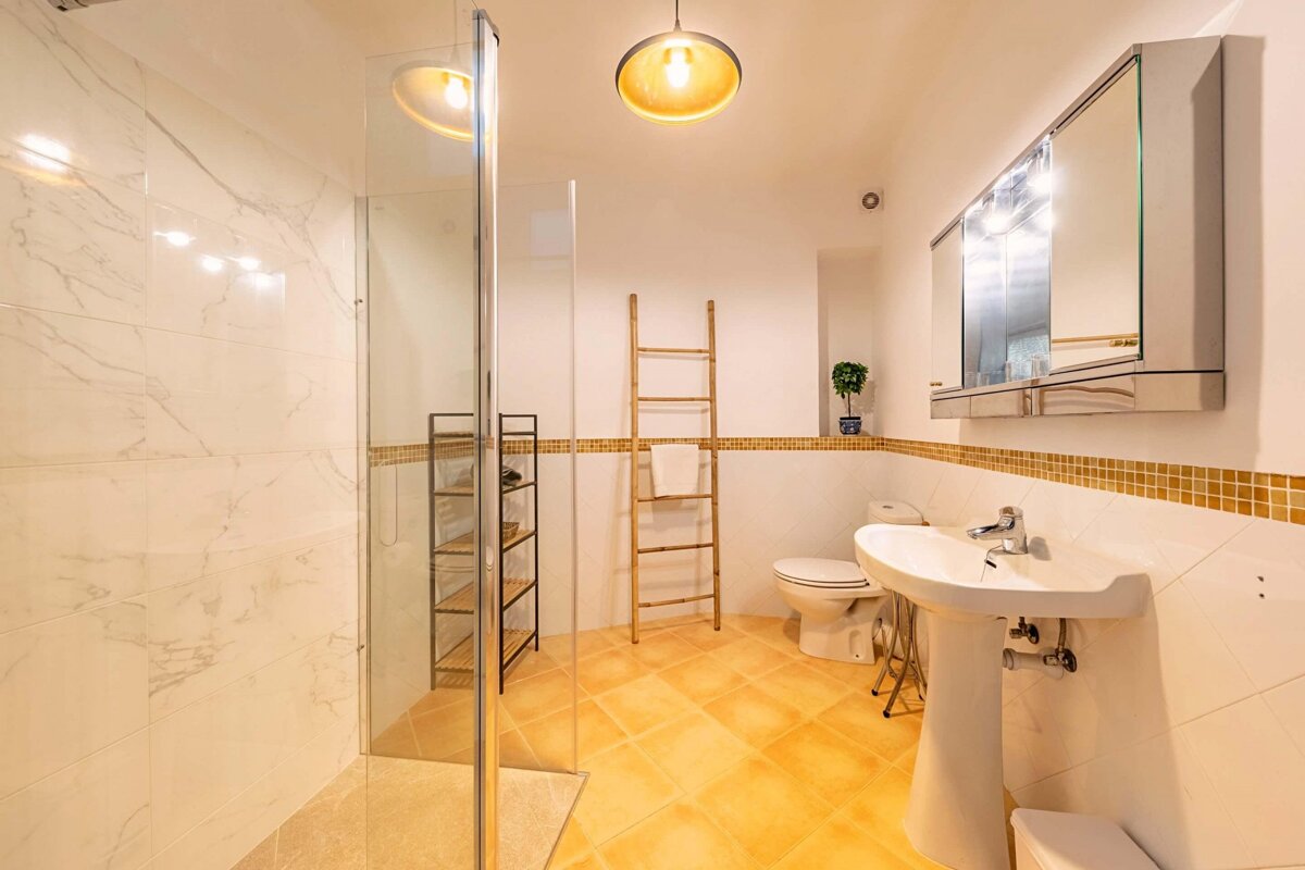 A bathroom with a toilet sink and walk in shower