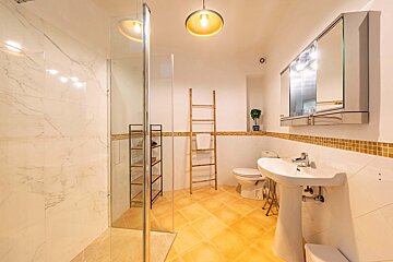 A bathroom with a toilet sink and walk in shower