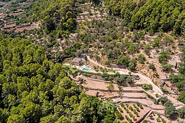 An aerial view of a house in the middle of a forest