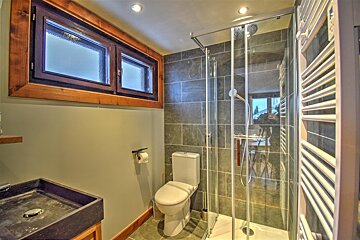 A bathroom with a toilet a sink and a walk in shower