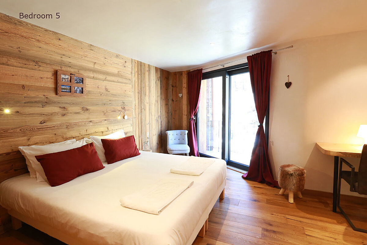 A bedroom with a large bed and the words bedroom 5 above it