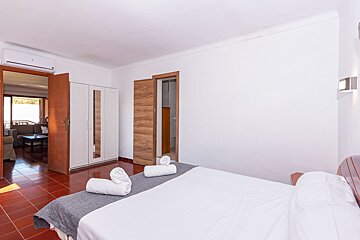 A bedroom with a king size bed and towels on the bed