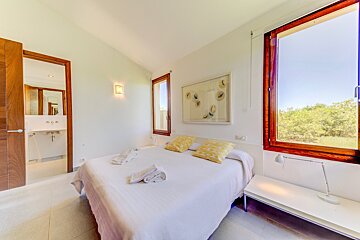 A bedroom with a large bed and a large window