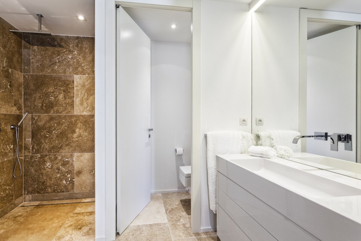 A bathroom with a walk in shower and a sink