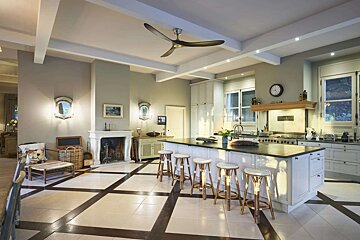 A kitchen with a large island and a ceiling fan