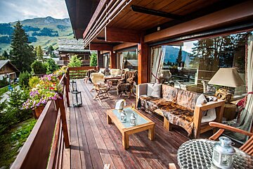 A wooden deck with a couch and chairs on it