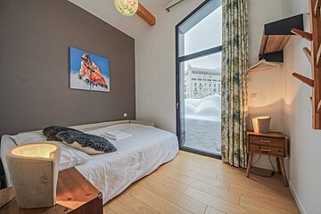A bedroom with a bed and a painting on the wall