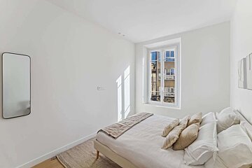 A bedroom with a large bed and a window